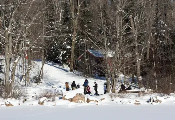 Group of youth in snow woods along shore