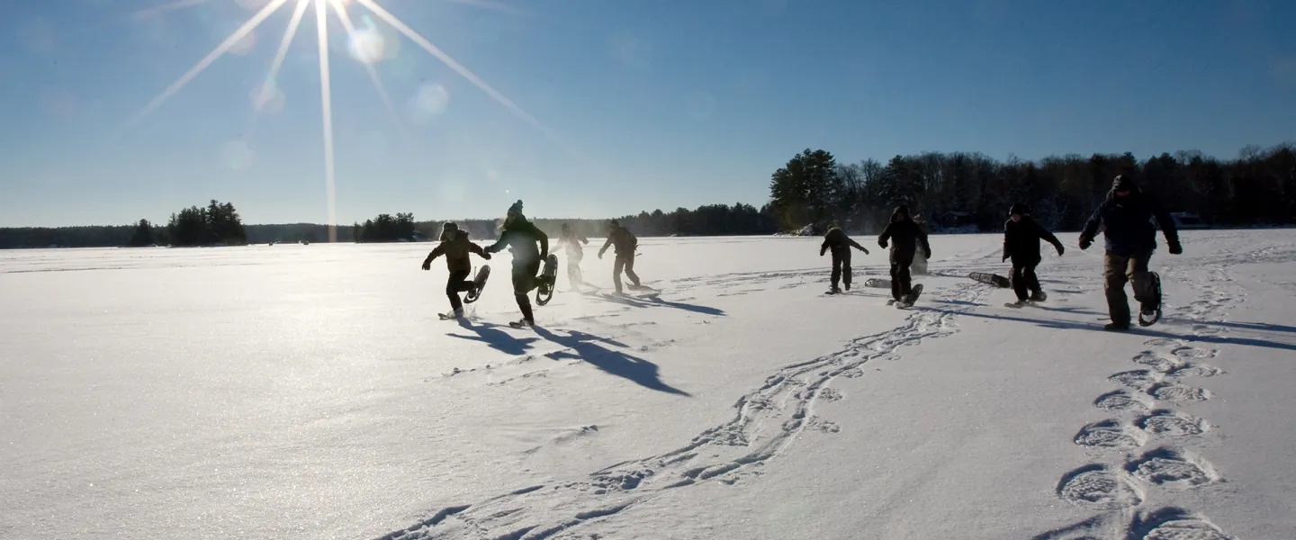 Youth snowshoeing on frozen lake