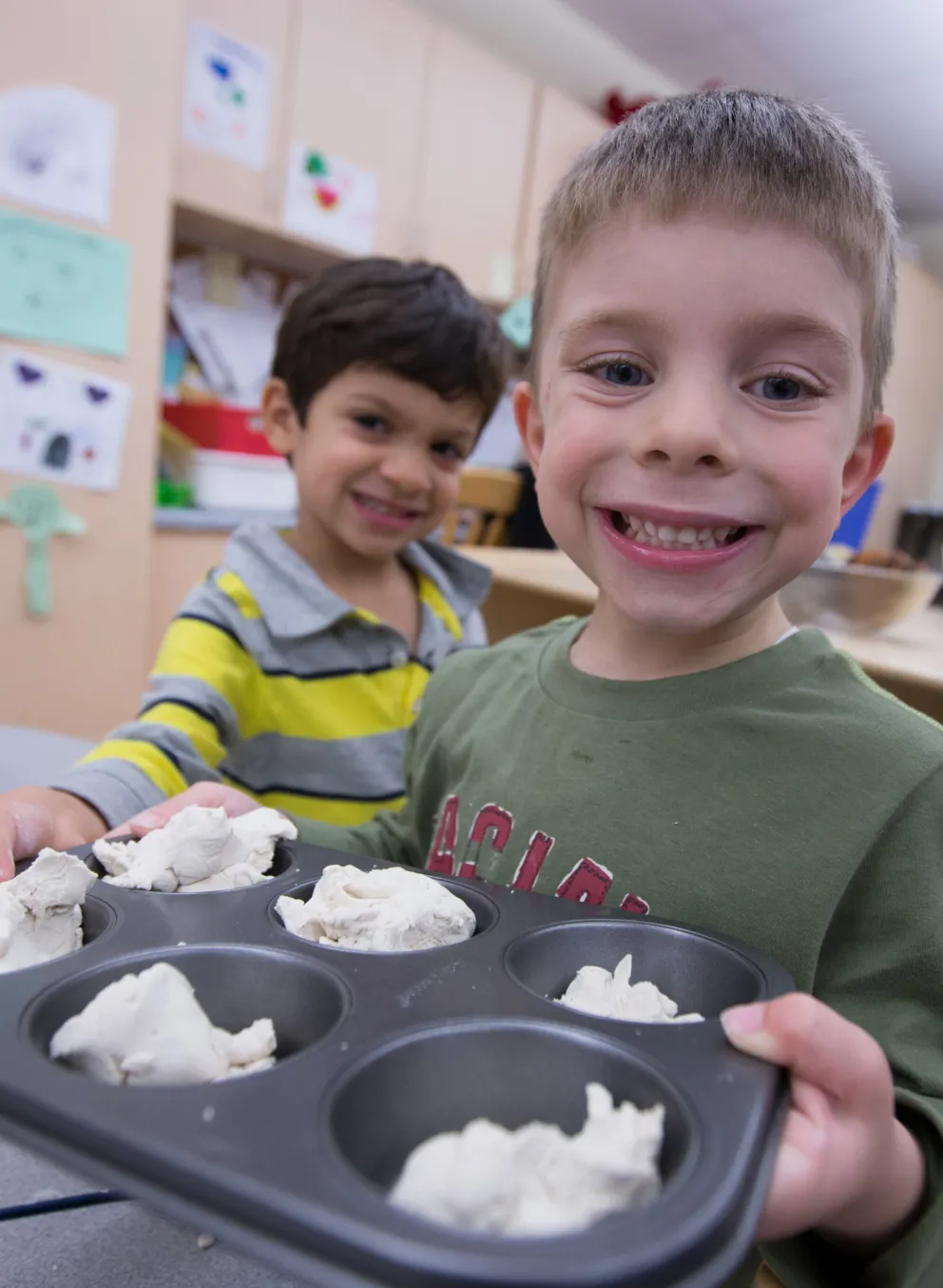 School age boys playing with playdough and baking tray