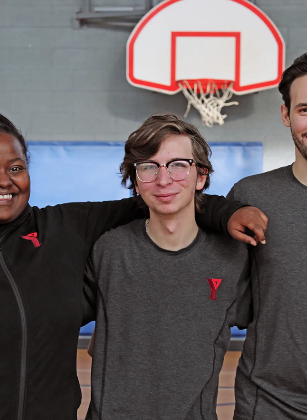 Young YMCA staff posing and smiling in main gym