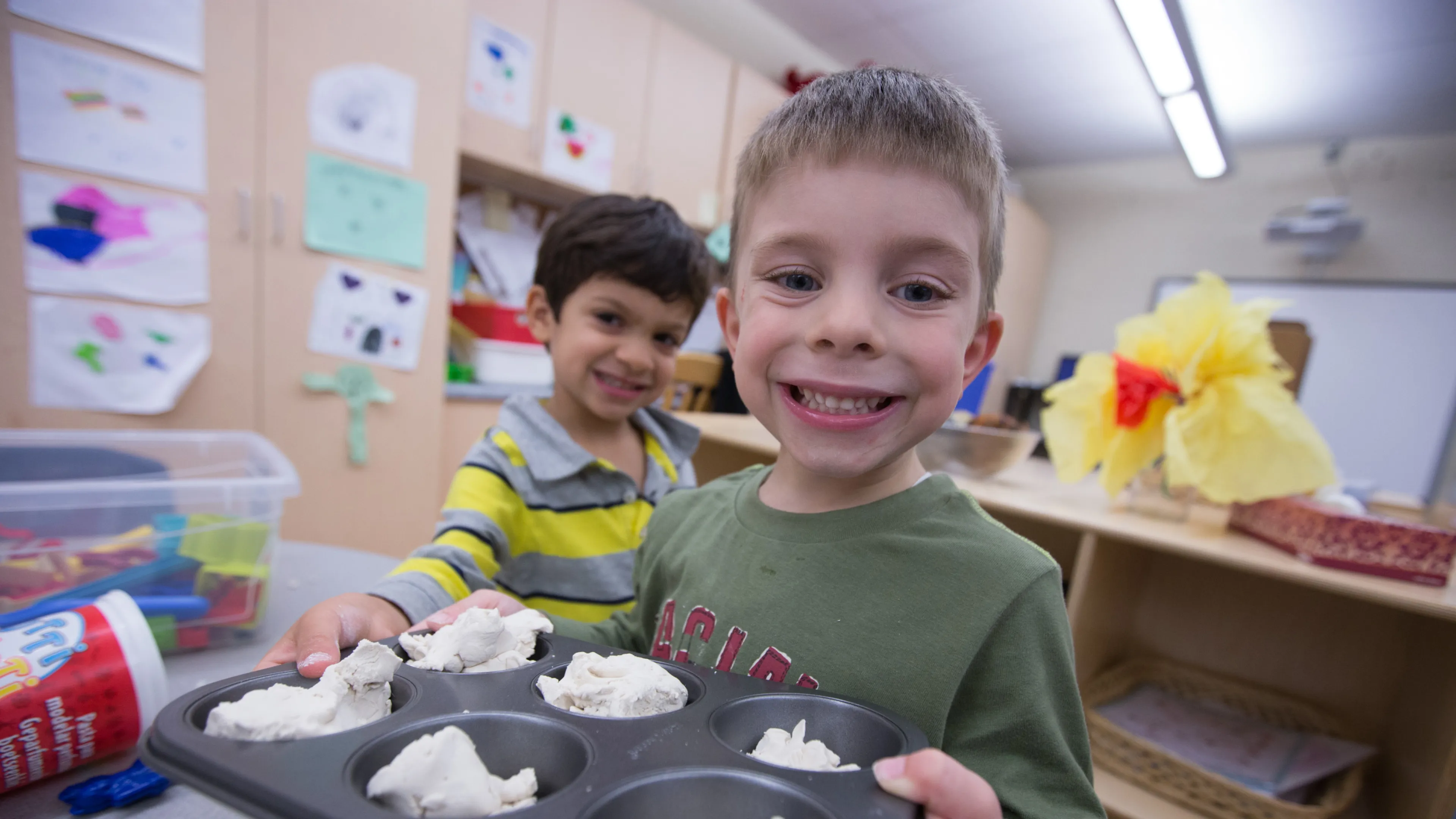 School age boys playing with playdough and baking tray