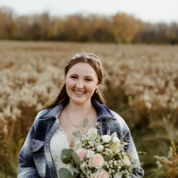 bride in field wearing blue flannel