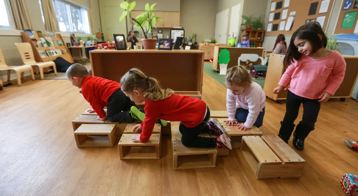 Multiple preschool children crawling on linear stepping blocks