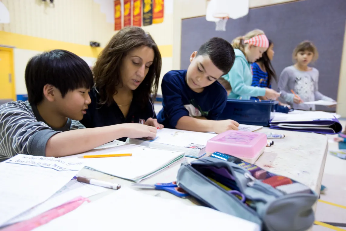 SACC Educator helping two boys with after school homework